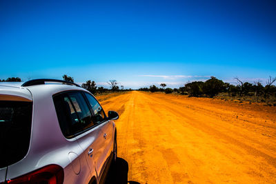 View of car on road against clear blue sky