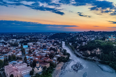 High angle view of buildings in town against sky during sunset