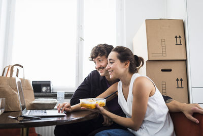 Couple eating lunch and using laptop