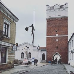 People walking on road amidst buildings in city