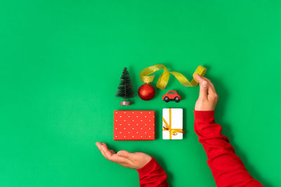 Cropped hand of woman holding gift against blue background