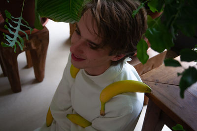 Man with banana sitting at home