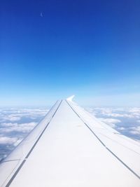 Airplane wing against blue sky