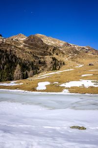 Scenic view of snowcapped mountains against clear blue sky