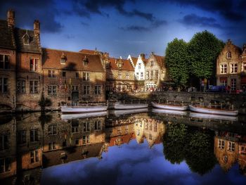 Reflection of buildings in lake against sky