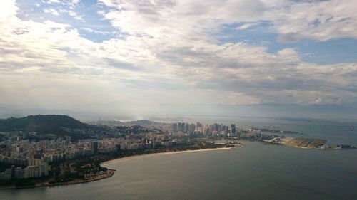 Cityscape by sea against sky