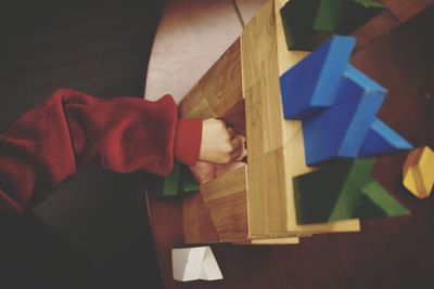 Cropped hand playing on table at home