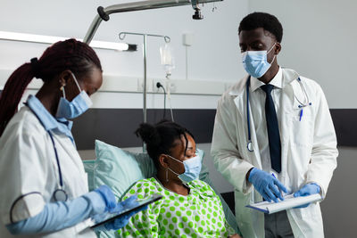 Doctors wearing mask examining patient in clinic