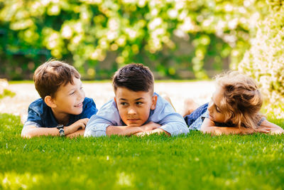 Portrait of friends lying on grass