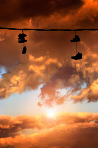 Low angle view of silhouette airshow against sky during sunset