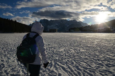 Rear view of man standing on snow covered landscape