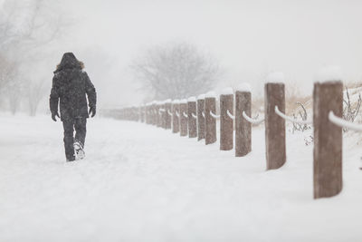 Rear view of man on snow covered field