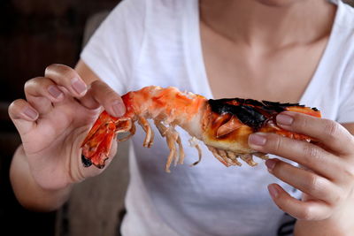 Midsection of woman holding shrimp