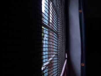 Low angle view of metal fence at night