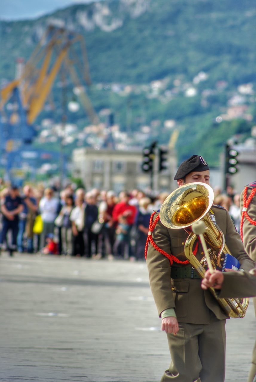 lifestyles, men, leisure activity, person, large group of people, focus on foreground, rear view, holding, food and drink, day, outdoors, casual clothing, street, tourist, city, walking, togetherness, mixed age range, standing