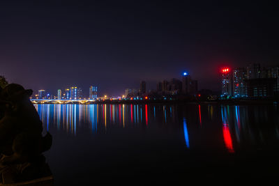 Reflection of illuminated city by river at night