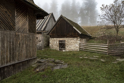 Old wooden house on field against sky