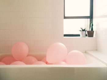 Balloons in bathtub at home