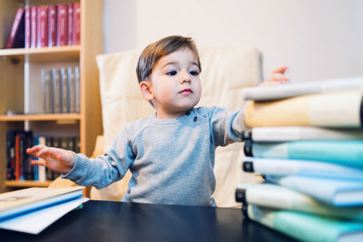Portrait of happy boy with book on table