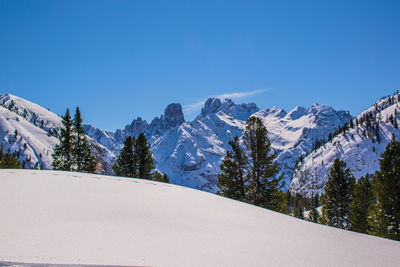 Scenic view of snowcapped mountains against clear blue sky