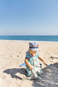 Boy on beach against clear sky