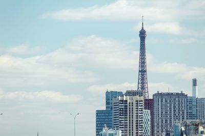 Modern buildings in city against cloudy sky