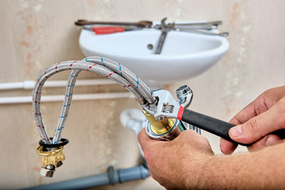 Cropped hand of man repairing pipe