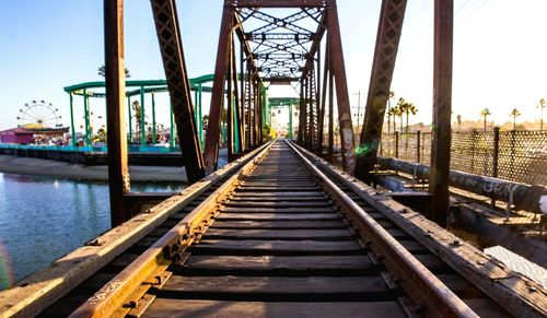 Railroad tracks by bridge against sky