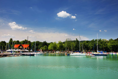 Boats in marina at harbor against sky