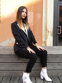 Young woman looking away while sitting outdoors
