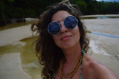 Portrait of young woman wearing sunglasses at the beach 