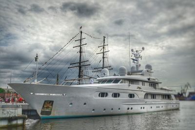 Boats moored at harbor against sky