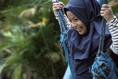 Happy girl swinging in park