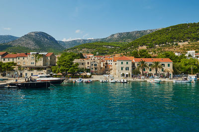 Buildings by sea against sky