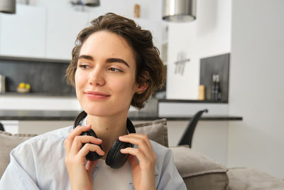 Portrait of young woman using mobile phone at home