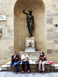 Statue of people sitting outside temple