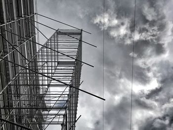 Low angle view of crane in building against sky