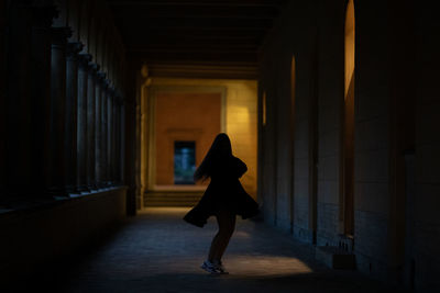 Woman walking in corridor of building