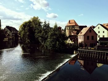 River amidst trees and buildings against sky