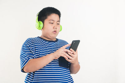 Full length of man using mobile phone against white background