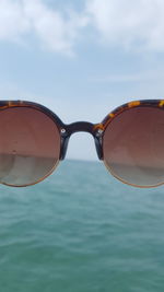 Close-up of sunglasses against sky