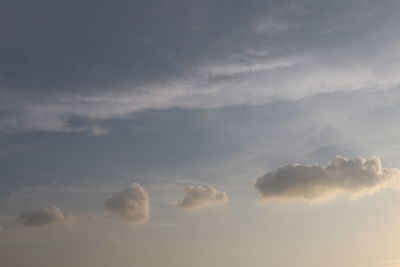 Low angle view of sunlight streaming through clouds