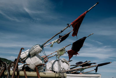 Low angle view of flags hanging on rope against sky