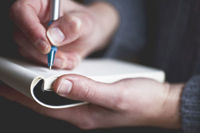 Close-up of man holding notebook