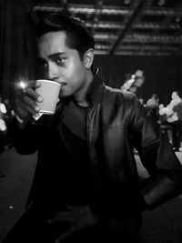 Midsection of man holding coffee cup