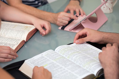 Midsection of woman reading book on table