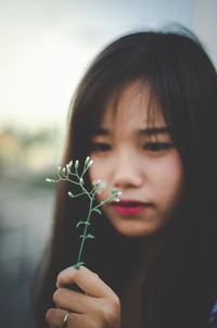 Close-up of beautiful woman holding plant
