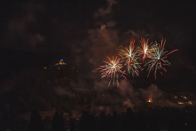 Low angle view of firework display at night