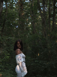 Full length of woman standing in forest