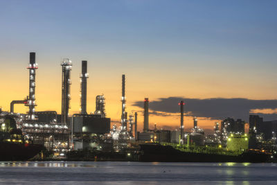 Illuminated factory against sky at night